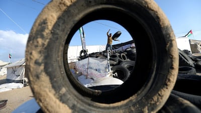 A man carries tyres to be burnt as Palestinians prepare to demonstrate along the border with the Gaza strip, east of Jabalia. Mohammed Abed / AFP