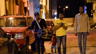 Yasser Al Samak, left, walks through the streets of Bilad Al Qadeem, a suburb of the Bahraini capital Manama, to awaken people for the Ramadan pre-dawn meal. AFP