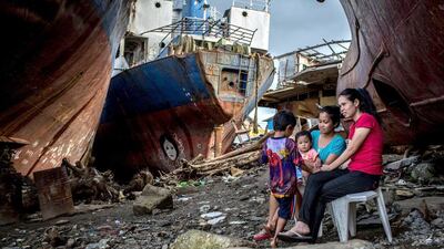 People relax in the shade of three large ships that were grounded by Typhoon Haiyan on April 18, 2014 in Tacloban, Leyte, Philippines. Chris McGrath / Getty Images