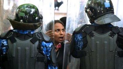 Maldivian policemen stand guard as a supporter of the former President Mohamed Nasheed protests during a rally in Male yesterday.