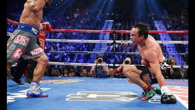 Manny Pacquiao, left, sends Juan Manuel Marquez to the mat in the fifth round of their WBO world welterweight fight. Eric Jamison / AP Photo