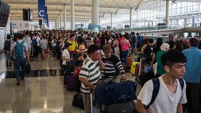 Passengers rest as they wait to find out the status of their flights after Typhoon Nida caused chaos at the international airport in Hong Kong. Hordes of angry passengers stranded after Typhoon Nida pummelled Hong Kong crowded the airport on Tuesday, desperately seeking flights as the city emerges from lockdown while the storm swept across southern China. Anthony Wallace / AFP