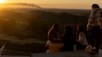 Israeli women in the southern city of Sderot look at smoke rising over the Gaza Strip on January 13. Getty Images.