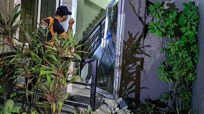 A BFP officer inspects a damaged building in Batac city, Ilocos Norte, after a 6.4-magnitude earthquake hit the northern Philippines. AFP