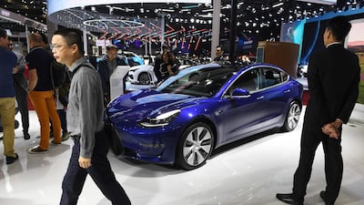 Visitors walk past a Tesla Model 3 at the Shanghai Auto Show in Shanghai on April 17, 2019. Tesla is investigating whether its Model S exploded while parked on a street in the Chinese city. AFP