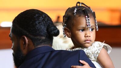 Memory, the 2-year-old daughter of Tomika Miller and Rayshard Brooks, is carried by a funeral home worker. EPA