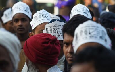 Supporters of the Jatiya Party, an alliance partner of ruling Prime Minister and Awami League-led chief Sheikh Hasina, are seen holding posters outside a polling station in Dhaka. AFP