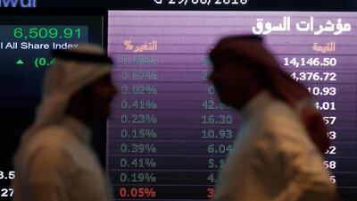 Investors talk with each other as they monitor a screen displaying stock information at the Saudi Stock Exchange (Tadawul) in Riyadh. Reuters