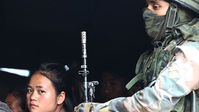 Soldiers help people to safety after ethnic violence in north-east India that has reportedly killed at least 54 people. AFP