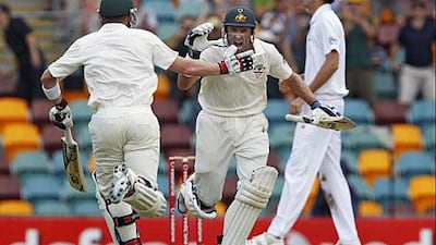 Australian batsman Mike Hussey celebrates his century with his batting partner Brad Haddin during the third day of the first Ashes cricket Test match