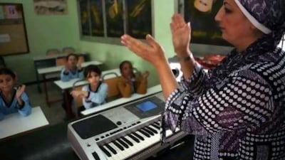 Dubai, UAE - December 10, 2009 - Teacher Shussoun Al Beik teaches a 4th grade music class at the National Charity School. (Nicole Hill / The National) *** Local Caption *** NH School00001.jpg