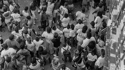 Cubans watch as a makeshift boat is carried to the sea.