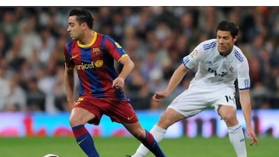Barcelona's Xavi, left, and Xabi Alonso of Real Madrid regularly line up on the same side for world champions Spain.