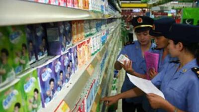 Chinese food safety officers inspect Mengniu branded milk at a supermarket in Fuyang, China.