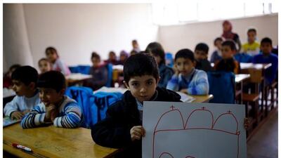 Syrian refugee Ali Ristmo, 7, as he shows his drawing depicting a mosque during a lesson in Yayladagi refugee camp in Hatay province near the Turkish-Syrian border, Turkey.