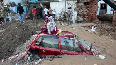 A car buried under mud along the banks of the overflowing Tawi river after heavy rain caused floods in Jammu, India. AFP
