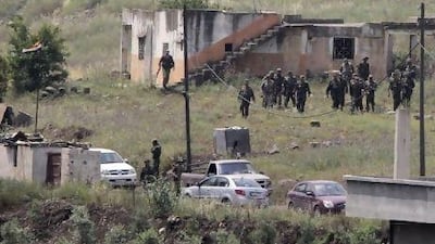 Syrian army soldiers reinforce the village of Arida near Talkalakh, opposite the Lebanon-Syria border, in Wadi Khaled, yesterday. The Syrian army shelled the town of Talkalakh on Wednesday night and earlyyesterday, which sparked gunbattles and brought the death toll from a five-day military siege to at least 34, according to human rights activists. Mohamed Azakir / Reuters