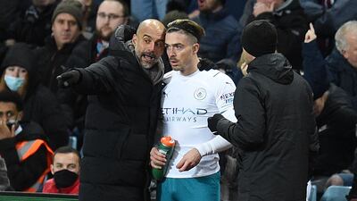 Manchester City's Spanish manager Pep Guardiola (L) speaks with Manchester City's English midfielder Jack Grealish (C) as he prepares to come on as substitute during the English Premier League football match between Aston Villa and Manchester City at Villa Park in Birmingham, central England on December 1, 2021. (Photo by Oli SCARFF / AFP) / RESTRICTED TO EDITORIAL USE. No use with unauthorized audio, video, data, fixture lists, club/league logos or 'live' services. Online in-match use limited to 120 images. An additional 40 images may be used in extra time. No video emulation. Social media in-match use limited to 120 images. An additional 40 images may be used in extra time. No use in betting publications, games or single club/league/player publications. /