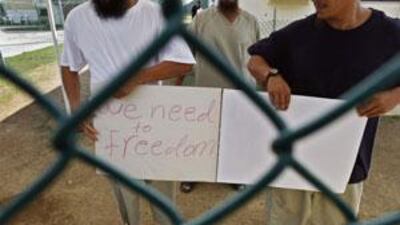 Chinese Uighur Guantanamo detainees, who at the time were cleared for release but had no country to go to, show a home-made note to visiting members of the media.