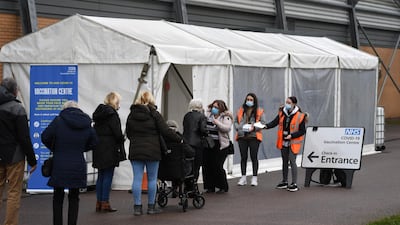 Members of the public wait in a queue to receive a dose of a Covid-19 vaccine at a coronavirus vaccination centre in Colchester, Essex, south-east England. AFP