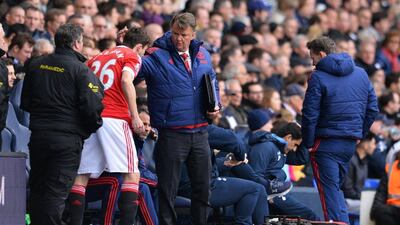 Manchester United manager Louis van Gaal, centre, speaks with Manchester United defender Matteo Darmian as he prepares to come onto the field during their Premier League match against Tottenham Hotspur at White Hart Lane in London, on April 10, 2016. AFP / GLYN KIRK