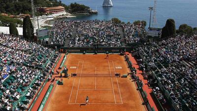 A sail boat passes by the central court as Roger Federer of Switzerland, bottom, prepares to serve against Lukas Rosol of the Czech Republic during the Monte Carlo Masters in Monaco on April 17, 2014. REUTERS/Eric Gaillard