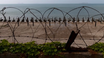 Metal spikes, known as dragon's teeth, and razor wire fortifications on a beach on Yeonpyeong Island, South Korea, with islands belonging to North Korea in the distance, June 26, 2020. On the sleepy island the threat of conflict is constant with North Korean coastal howitzers just 11 kilometres away. Bloomberg
