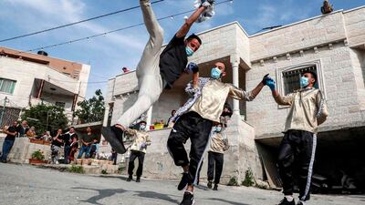 Dancers of the Palestinian Jafra Dabke Team perform a traditional dabke dance for people confined because of the coronavirus pandemic lockdown in the village of Tarqumia, north-west of Hebron, in the occupied West Bank. AFP
