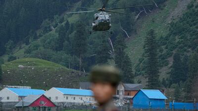 A soldier stands guard as a helicopter evacuates civilians in flooded areas in Srinagar, Indian-administered Kashmir, on July 9. The sentencing of a high-profile separatist has heightened tensions in the region. AP