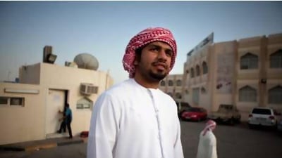 Abdulla Al Hammadi, 23, stands in front of the Hamdan Bin Mohamed School in Baniyas west, near Abu Dhabi, where he attends Grade 10 evening classes for adults. Silvia Razgova / The National