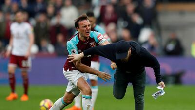 West Ham United's Mark Noble clashes with a fan who has invaded the pitch. Action Images via Reuters / Peter Cziborra