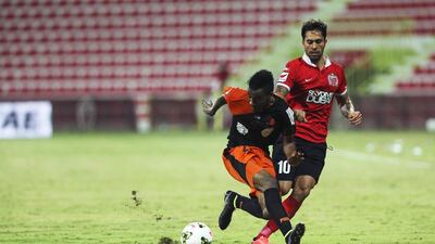 Ajman's Masoud Hassan, left, fights for the ball with Al Ahli's Luis Jimenez during their Arabian Gulf League match at Rashid Stadium in Dubai on September 29, 2014. Sarah Dea / The National
