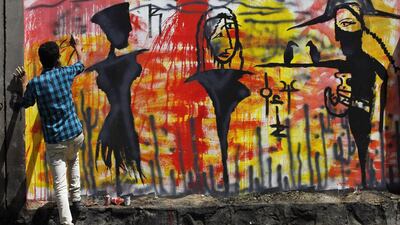 A Yemeni activist paints graffiti on a wall in protest of the ongoing unrest in the country, in Sana’a, Yemen. Yahya Arhab / EPA