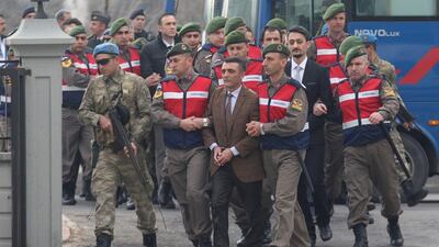 Zekeriya Kuzu, one of the main suspects accused of attempting to assassinate Turkish president Tayyip Erdogan on the night of a failed coup attempt on July 15, 2106, and the other soldiers are escorted by Turkish gendarmes as they arrive for the first hearing of their trial in Mugla, Turkey, on February 20, 2017. Kenan Gurbuz / Reuters