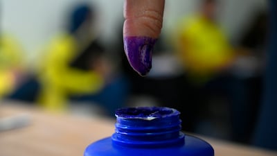 A woman dips her finger in indelible ink after casting her ballot at a polling station in Beirut, Lebanon. EPA