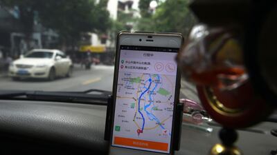 A taxi driver using the Didi Chuxing app while driving along a street in China's southern Guangxi region. Didi Chuxing's safety lapses forced it to shut down its group ride sharing service last year. AFP