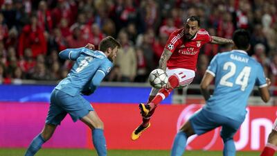 Benfica player Mitroglou (C) kicks the ball as Nicolas Lombaerts (L) and Ezequiel Garay (R) of FC Zenit St. Petersburg look on during their UEFA Champions League round 16, first leg soccer match, held at the Luz stadium in Lisbon, Portugal, 16 February 2016. EPA/MANUEL DE ALMEIDA