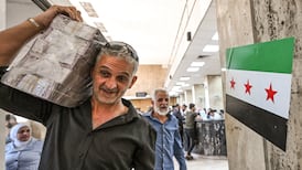 A man carrying Syrian pounds leaves the central bank in Damascus, in May 2025. Inflation is expected to rise. AFP