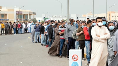 Expatriates wait in line to be tested at a makeshift centre, following the outbreak of coronavirus, in Mishref, Kuwait. REUTERS