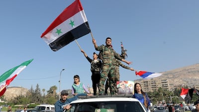 Soldiers waved the national flag as well as Iranian and Russian ones. Youssef Badawi / EPA