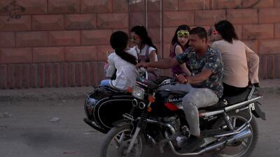 People ride a motorcycle with sidecar during Eid Al Fitr, in Toukh, Al Qalyubia Governorate, north of Cairo, Egypt. Reuters