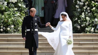 Britain's Prince Harry, Duke of Sussex and his wife Meghan, Duchess of Sussex emerge from the West Door of St George's Chapel, Windsor Castle. For their wedding on May 19, 2018, the Duchess of Sussex wore a Givenchy dress designed by Clare Waight Keller. AFP