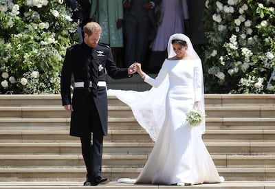 Britain's Prince Harry, Duke of Sussex and his wife Meghan, Duchess of Sussex emerge from the West Door of St George's Chapel, Windsor Castle, in Windsor, on May 19, 2018 after their wedding ceremony. / AFP / POOL / Jane Barlow