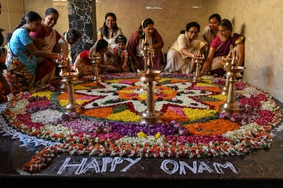 Devotees prepare a floral rangoli said to welcome king Mahabali. AFP