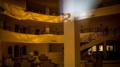 The lobby of an abandoned resort is seen through a window.