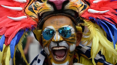 A fan makes an impression while watching the Group G match between Belgium and Egypt during a screening at the Fifa Fan Festival at Zocalo Square in Mexico City. AFP