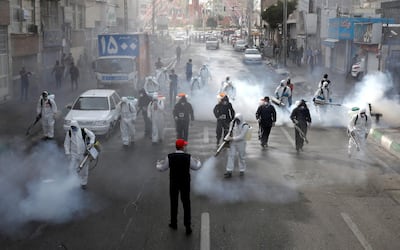 Iranian Firefighters disinfect streets in the capital Tehran in a bid to halt the wild spread of coronavirus on March 13 2020. - Iranian forces will clear the streets nationwide within 24 hours and all citizens will be checked for the new coronavirus in a bid to halt its spread, the military said. (Photo by - / AFP)