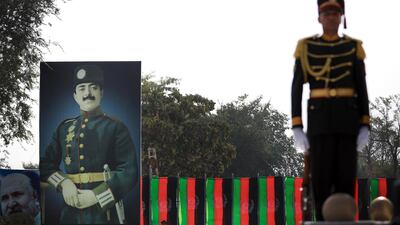 An Afghanistan guard of honour officer stands next to the billboard of King Amanullah Khan, who led Afghanistan to independence. EPA