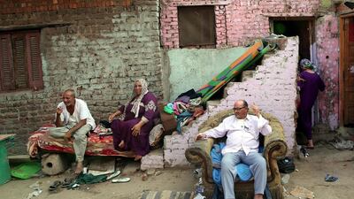 Egyptians gather in front of their houses at a slum near the Nile City Towers in Ramlet Bulaq neighborhood, Cairo, Egypt. Khaled Elfiqi / EPA