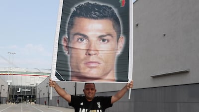 A Juventus supporter holds a banner bearing the picture of Ronaldo in front of the Juventus medical center. AFP